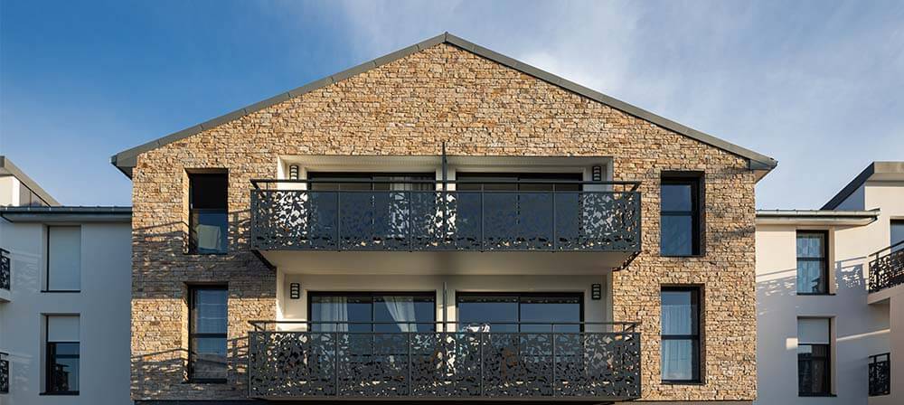house with balconies and natural stone wall cladding