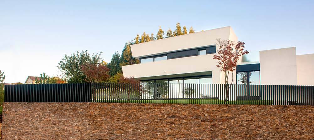 modern house with a wall covered in orange coloured natural stone